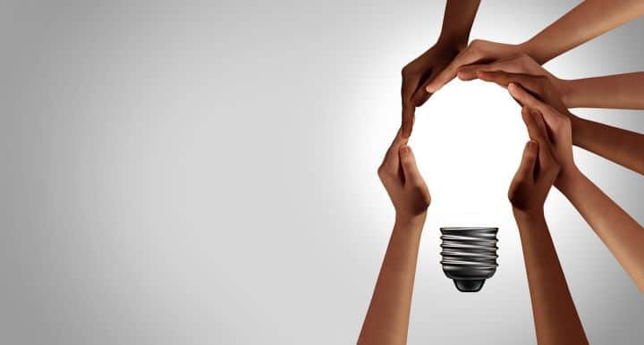 An Image of Several People Holding Their Hands in the Shape of a Light Bulb Representing Collective Ideas