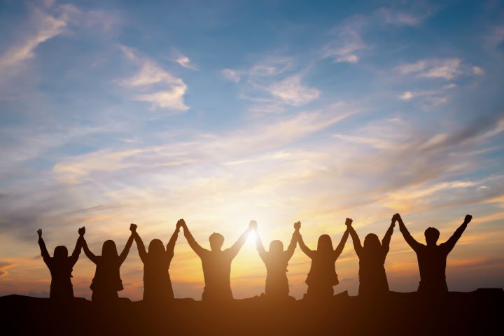 An Image of Several People with Held Hands Lifted High Representing Them Celebrating Their Success