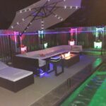 The Founder of CoolBiz Web Design's Swimming Pool at Night with Glowing LED Lights and and a Fire Table