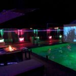 The Founder of CoolBiz Web Design's Swimming Pool at Night with Glowing LED Lights and an Outdoor Movie Screen