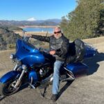 Picture of CoolBiz Web Design's Founder Sitting on a Harley Davidson in Front of the Three Shastas; Shasta Dam, Shasta Lake, and Mt. Shasta