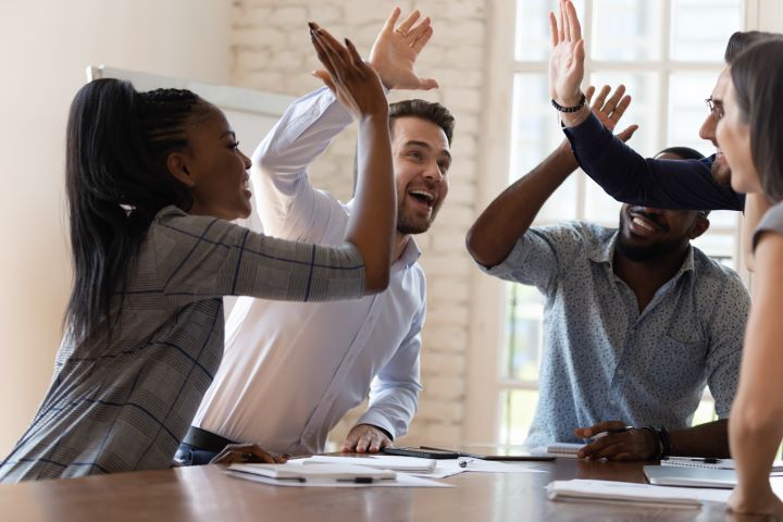 An Image of Several People Giving High Fives to Each Other Representing Teamwork